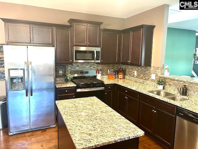 kitchen featuring light stone countertops, backsplash, stainless steel appliances, sink, and dark hardwood / wood-style floors