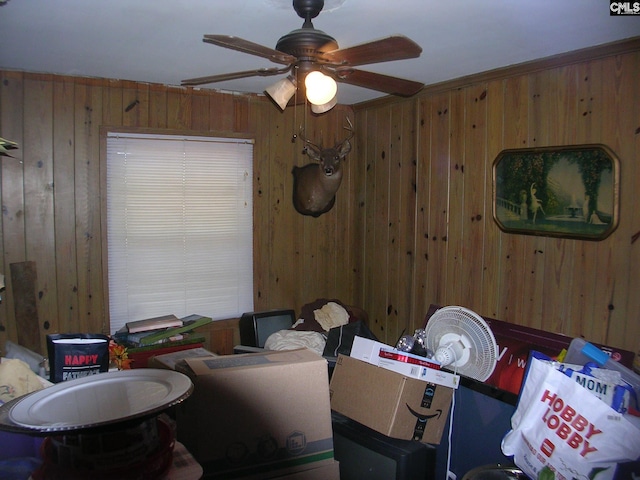 interior space featuring wooden walls and ceiling fan