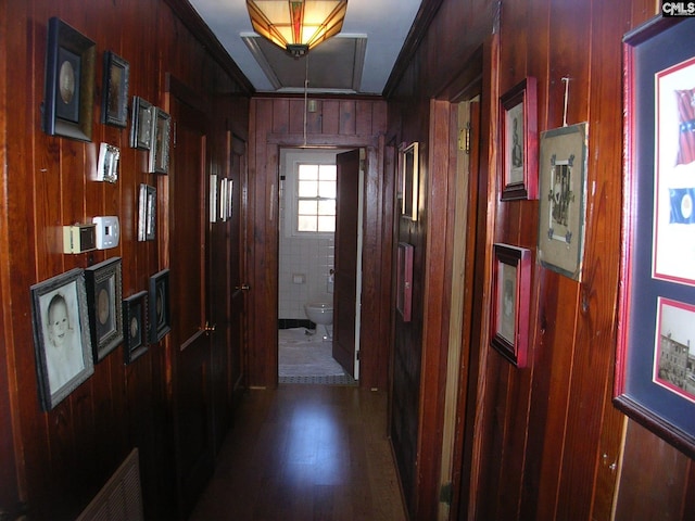 hallway featuring crown molding and wooden walls