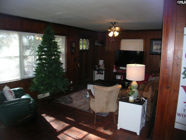 living room featuring wood walls and ceiling fan