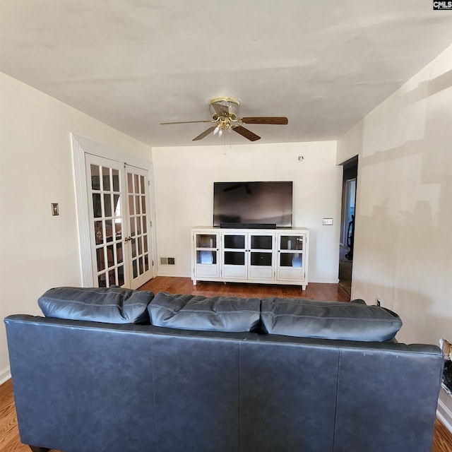 living room featuring ceiling fan, dark hardwood / wood-style flooring, and french doors