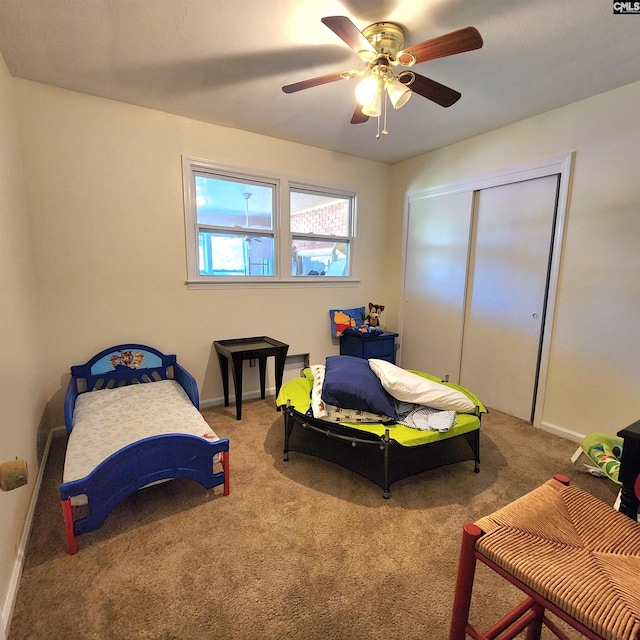 carpeted bedroom featuring ceiling fan and a closet