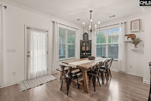 dining area featuring hardwood / wood-style floors, a notable chandelier, and crown molding