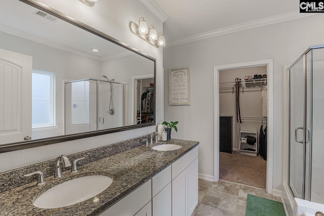 bathroom with vanity, a shower with door, and crown molding