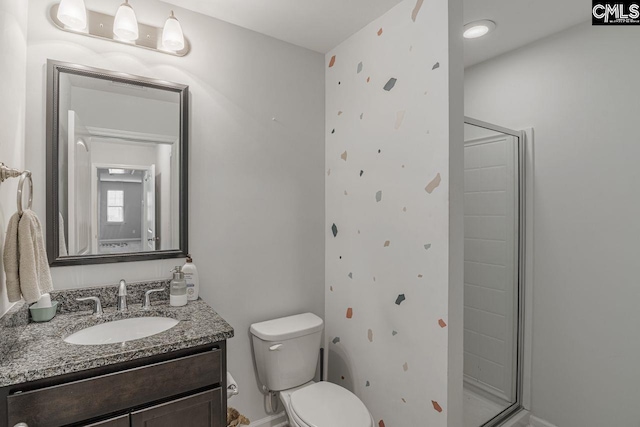 bathroom featuring vanity, toilet, and a shower with door