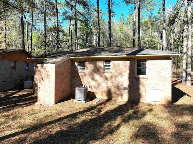 view of property exterior featuring central AC unit and a yard