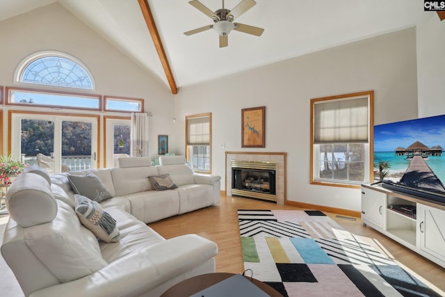 living room featuring light wood-type flooring, high vaulted ceiling, and a healthy amount of sunlight