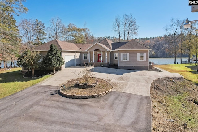 ranch-style house with a front yard, a water view, and a garage