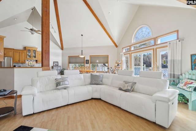 living room featuring ceiling fan, high vaulted ceiling, and light hardwood / wood-style floors