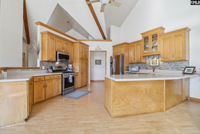 kitchen with kitchen peninsula, decorative backsplash, light wood-type flooring, stainless steel appliances, and high vaulted ceiling