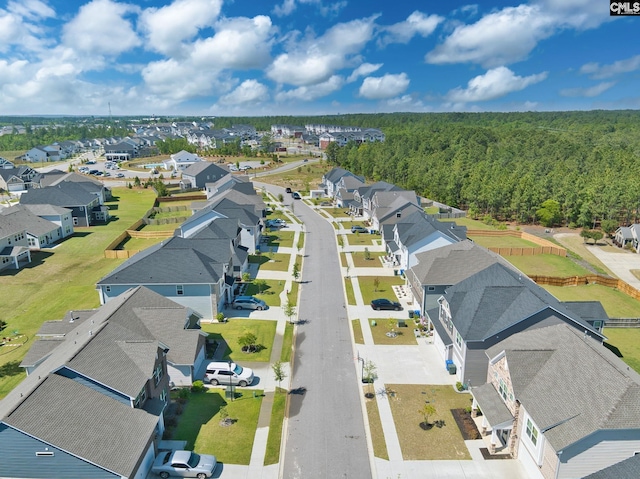 drone / aerial view featuring a residential view and a wooded view