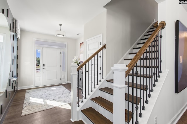 entryway featuring dark wood finished floors and baseboards