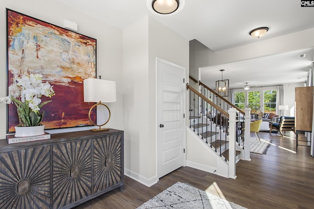 entryway with stairs, baseboards, and wood finished floors