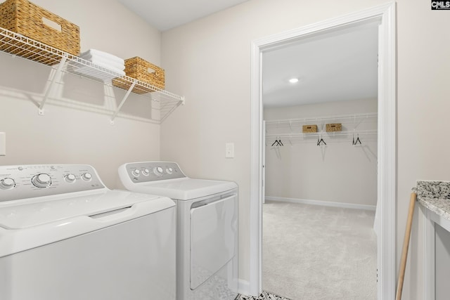 laundry room with laundry area, baseboards, washing machine and clothes dryer, and light colored carpet