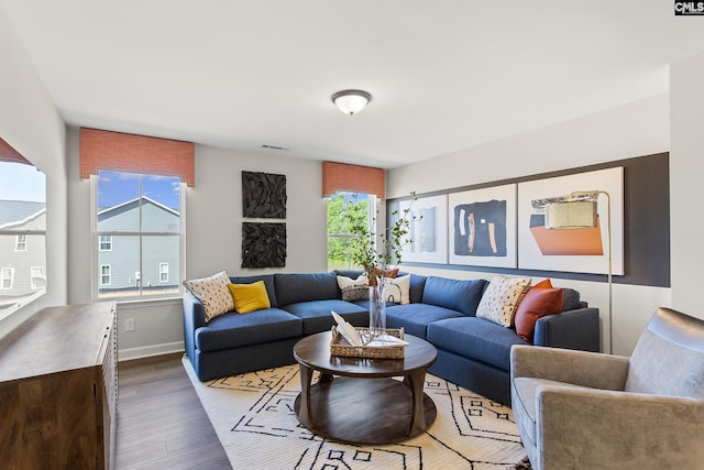 living room featuring visible vents, baseboards, and wood finished floors