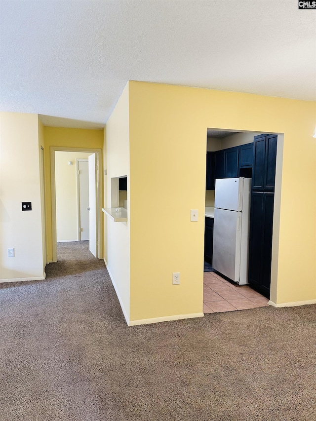 carpeted empty room with a textured ceiling