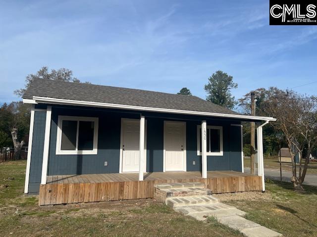 view of front of property featuring covered porch and a front lawn