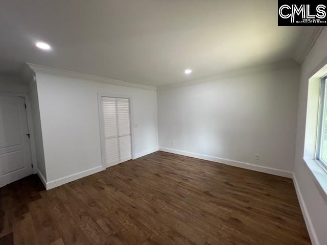 spare room with dark hardwood / wood-style floors and crown molding