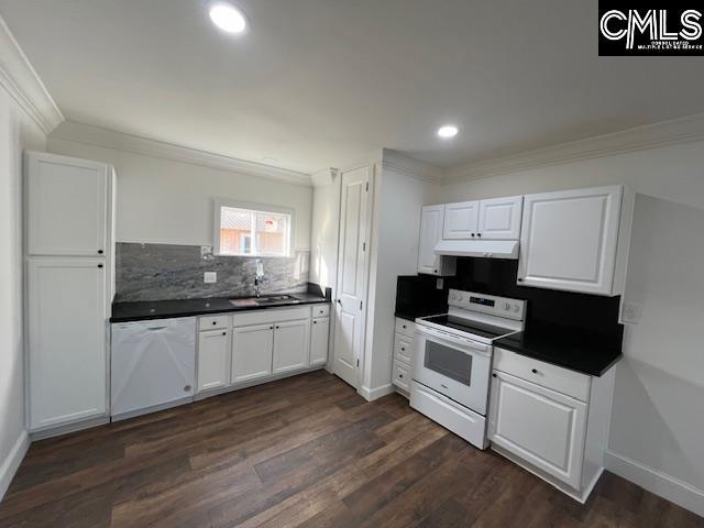 kitchen with white appliances, dark wood-type flooring, white cabinets, sink, and decorative backsplash