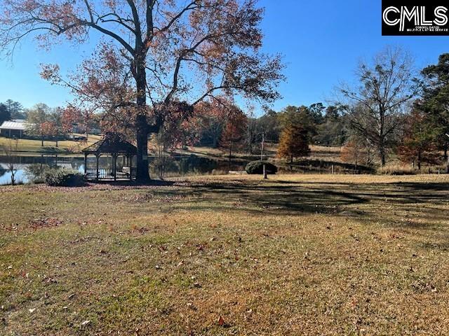 view of yard featuring a gazebo and a water view