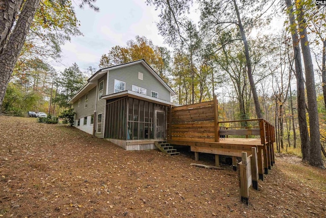 back of property featuring a wooden deck and a sunroom