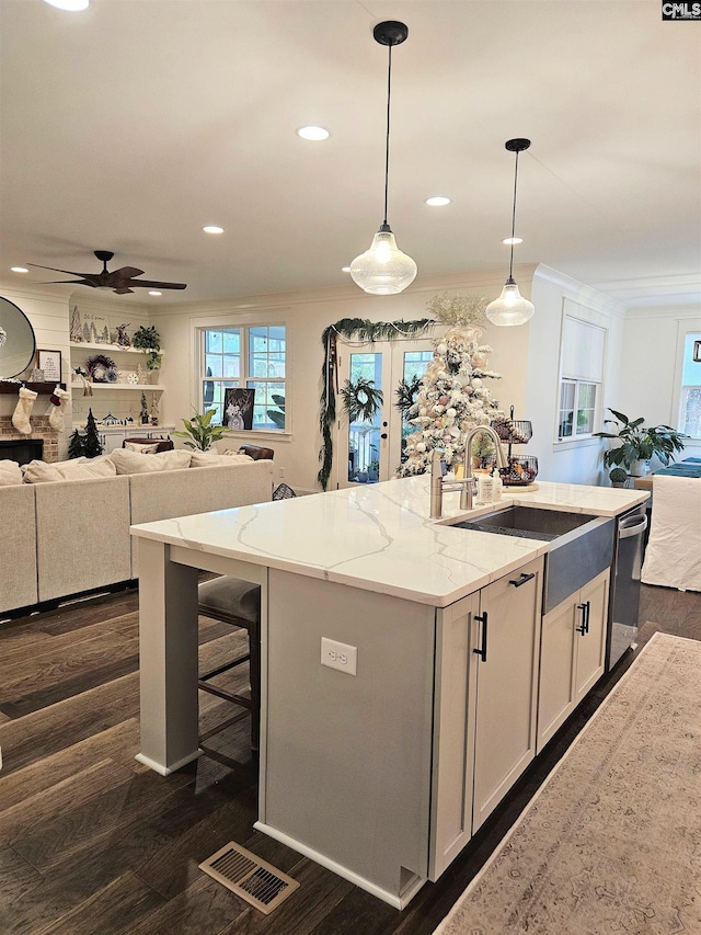 235 Clayborn Dr, Lexington, SC 29072 - kitchen featuring light stone counters, crown molding, pendant lighting, white cabinetry, and an island with sink