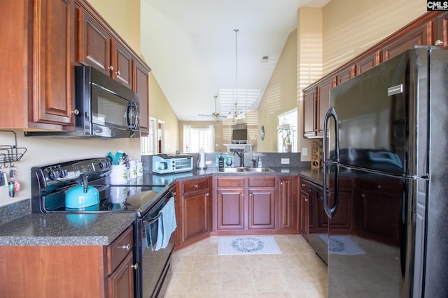 kitchen with sink, vaulted ceiling, decorative light fixtures, black appliances, and ceiling fan with notable chandelier