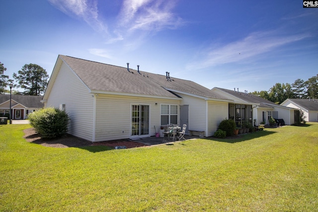 rear view of house with a patio and a lawn