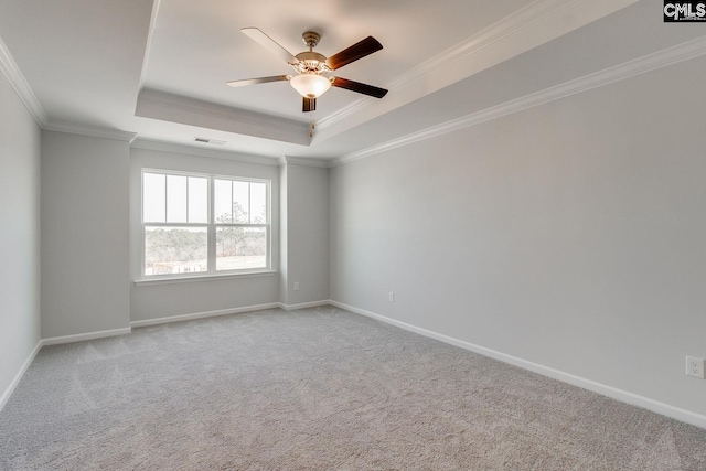 carpeted empty room featuring a tray ceiling, ceiling fan, and ornamental molding