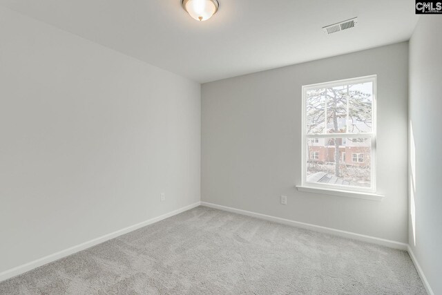 spare room with baseboards, visible vents, and carpet flooring