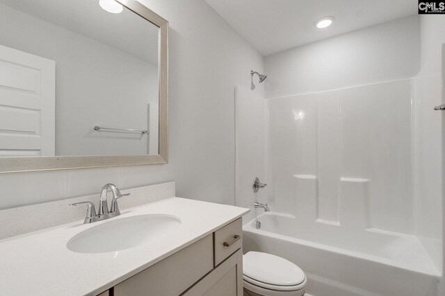 bathroom with toilet,  shower combination, and vanity