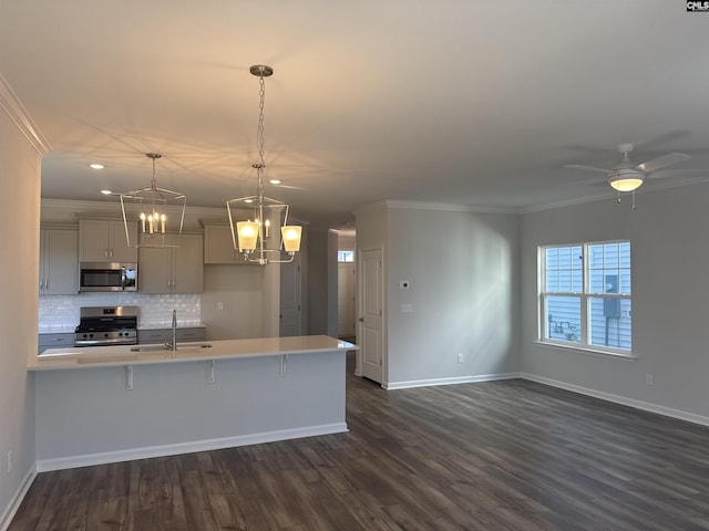 kitchen with stainless steel appliances, a sink, a kitchen breakfast bar, and ornamental molding