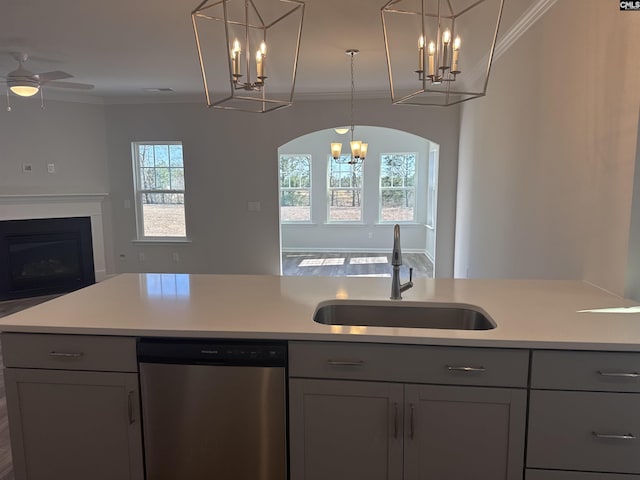 kitchen with gray cabinets, a sink, open floor plan, and stainless steel dishwasher