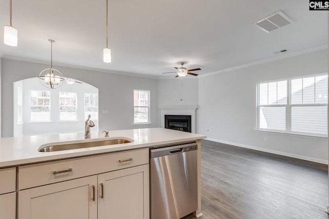 kitchen featuring visible vents, dishwasher, ornamental molding, a fireplace, and a sink