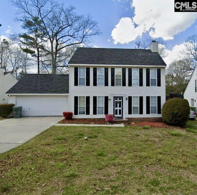 colonial home with a front yard and a garage