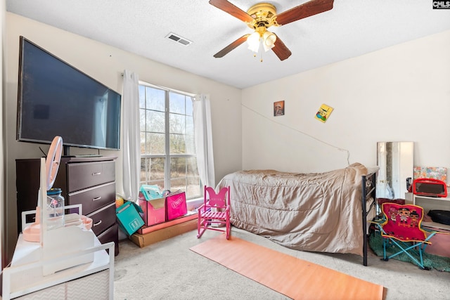 carpeted bedroom with a textured ceiling and ceiling fan