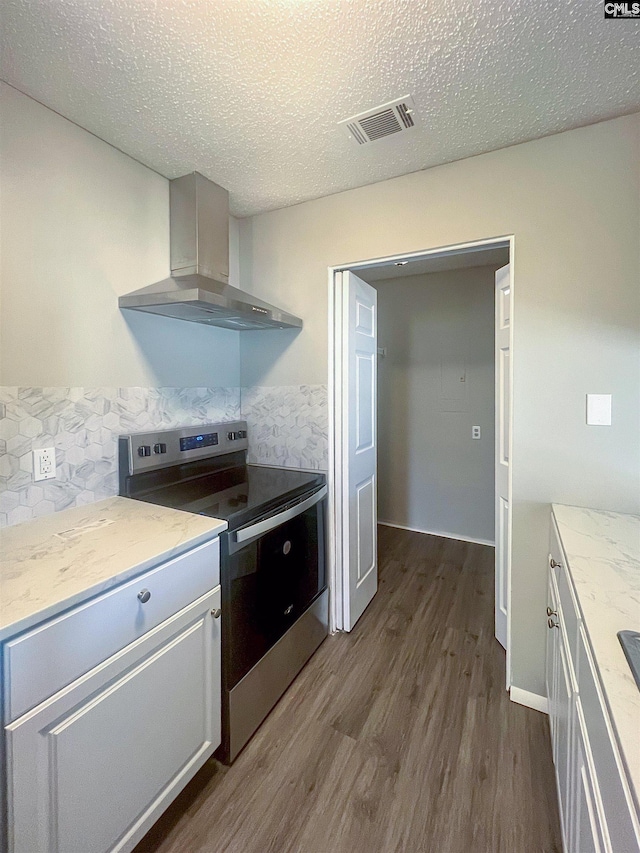 kitchen featuring stainless steel range with electric cooktop, a textured ceiling, light stone countertops, ventilation hood, and dark wood-type flooring