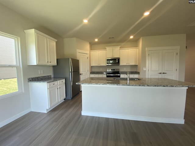 kitchen featuring a kitchen island with sink, sink, dark hardwood / wood-style floors, appliances with stainless steel finishes, and white cabinetry