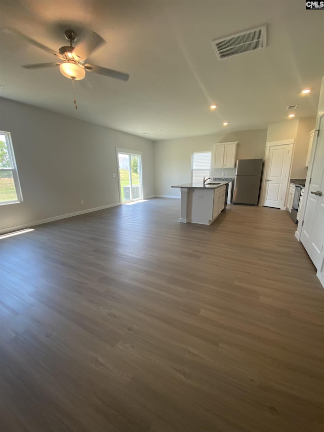 unfurnished living room featuring ceiling fan, dark hardwood / wood-style flooring, and sink