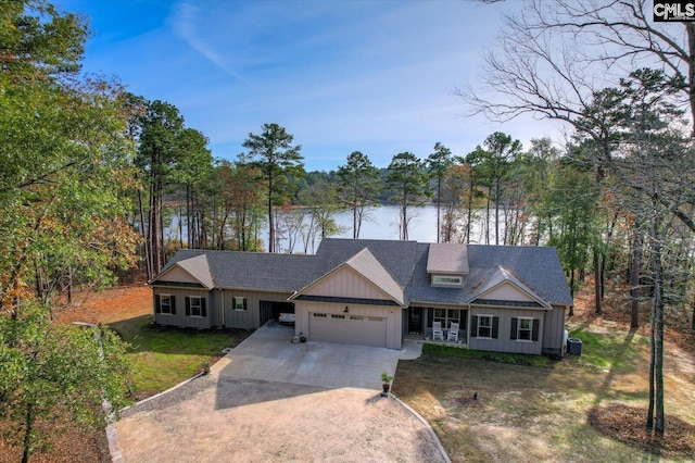 view of front of property with a garage, a water view, central air condition unit, and a front yard