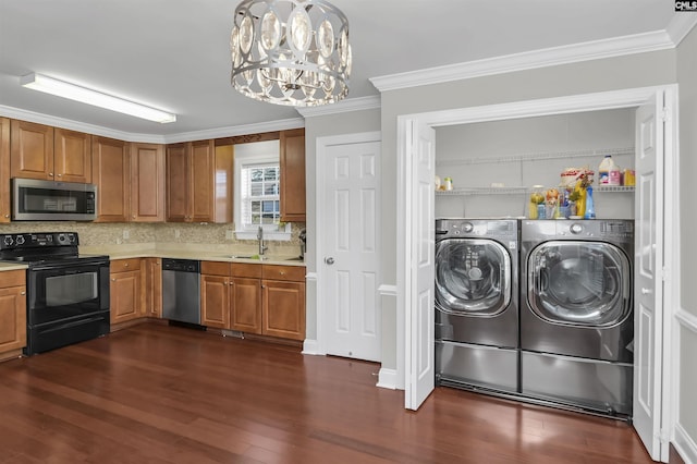 interior space with crown molding, sink, a notable chandelier, washing machine and dryer, and dark hardwood / wood-style floors