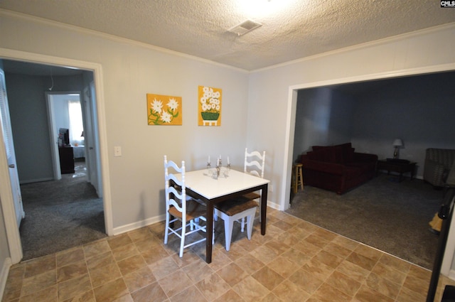 dining area featuring carpet flooring, a textured ceiling, and ornamental molding