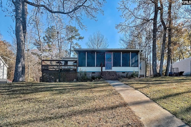 view of front of house with a front lawn, a wooden deck, and a sunroom