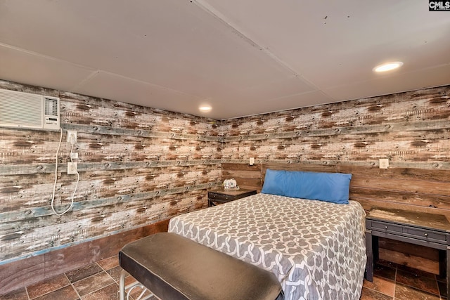 bedroom with wooden walls and a wall mounted air conditioner