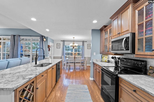 kitchen with light wood-type flooring, stainless steel appliances, a healthy amount of sunlight, and sink