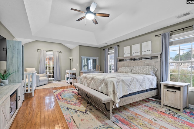 bedroom featuring a tray ceiling, light hardwood / wood-style flooring, and ceiling fan