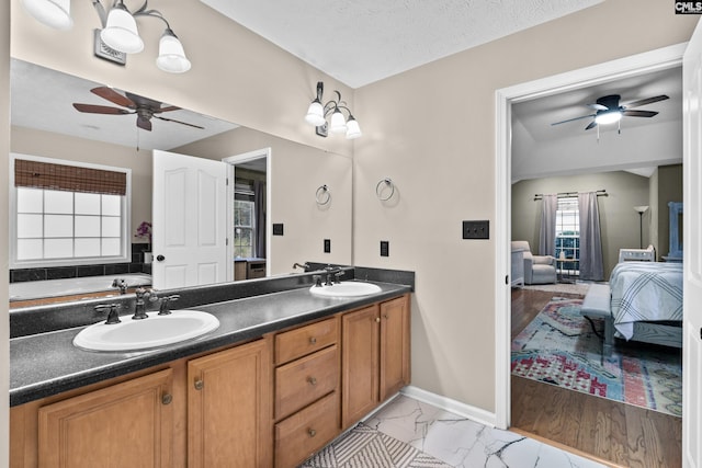 bathroom featuring ceiling fan, vanity, a textured ceiling, and hardwood / wood-style flooring