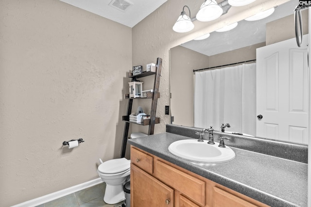 bathroom featuring tile patterned flooring, vanity, and toilet