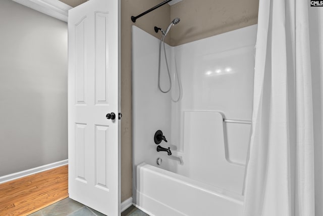 bathroom with hardwood / wood-style floors and shower / bath combination with curtain