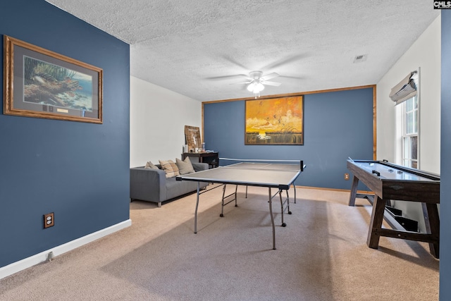 game room featuring a textured ceiling, light colored carpet, and ceiling fan